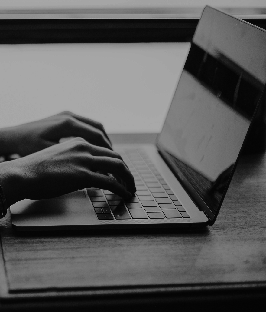 Hands typing on a laptop