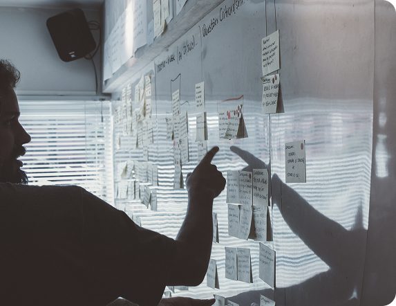 Founders mapping a plan on a wall of sticky notes